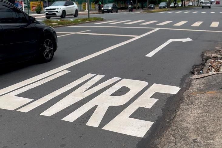 Sinalização da Direita Livre pintada no asfalto, com a palavra LIVRE e seta de conversão à direita, em cruzamento de Goiânia