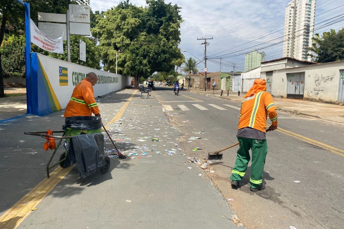 Trabalhadores da Comurg fazem varrição de material de campanha na porta de uma escola