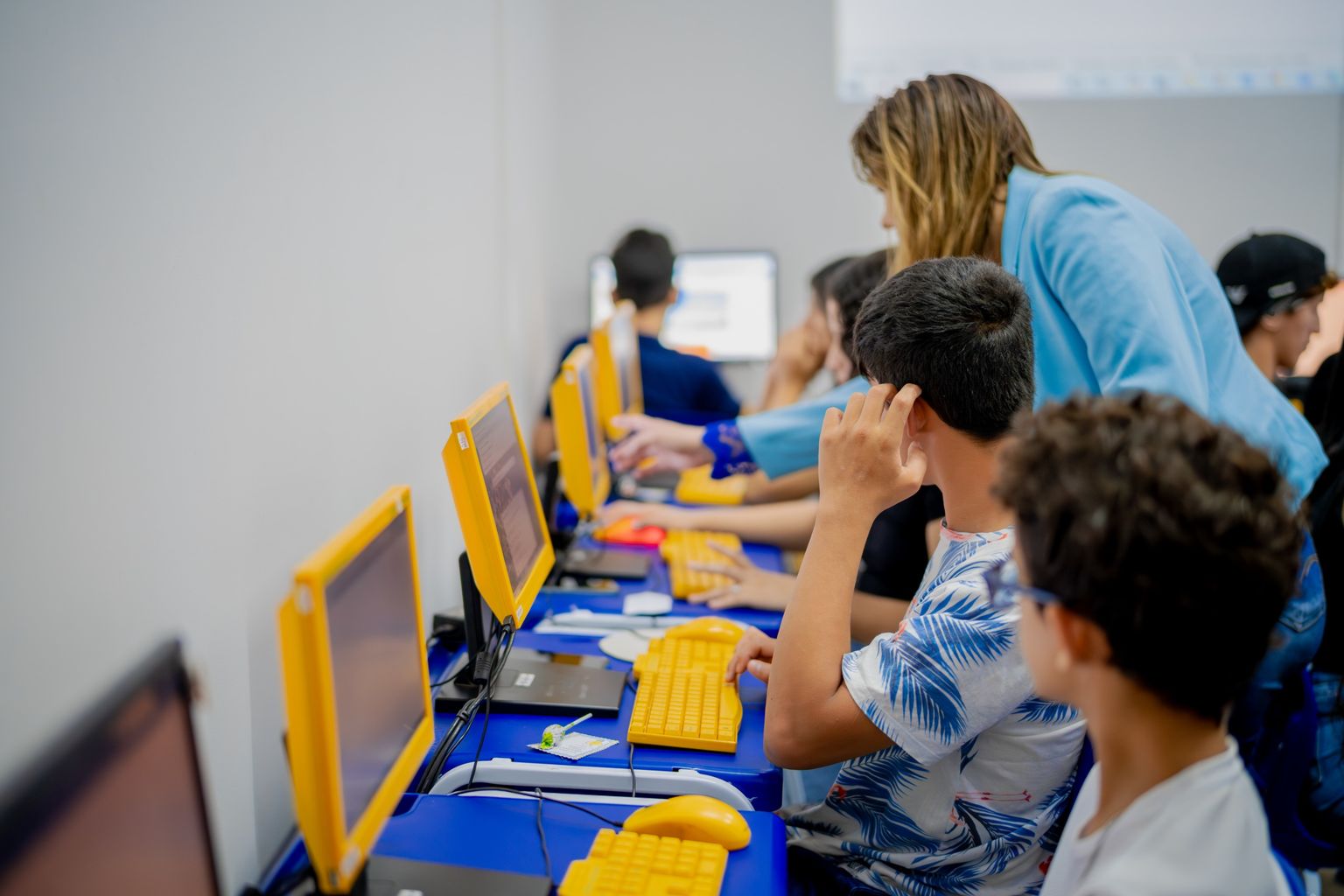 Estudantes em frente a computadores durante aula em laboratório de informática em Anápolis