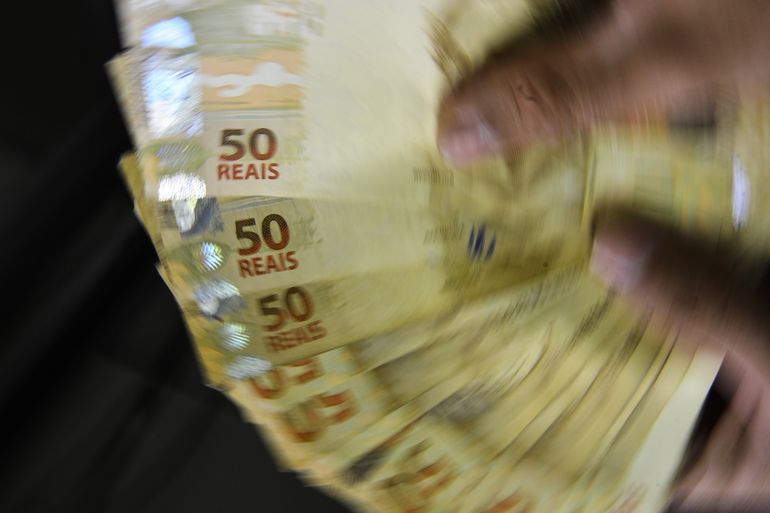 Cédulas de real sobre a mesa ilustram o cálculo de precatórios e RPVs