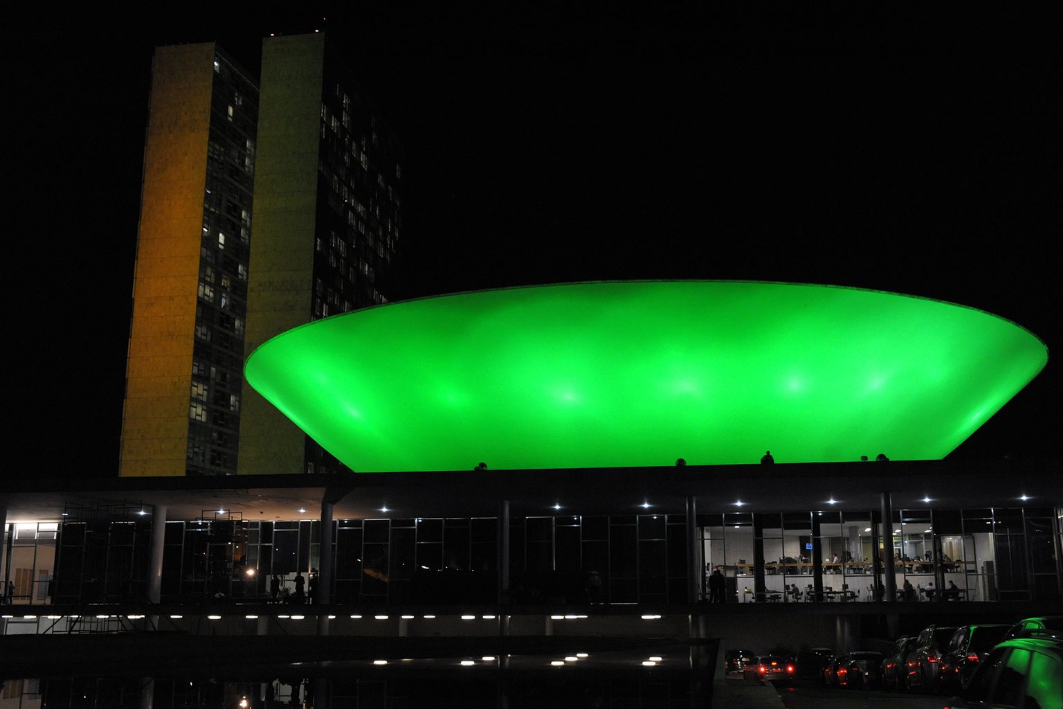 Cúpula do plenário da Câmara dos Deputados iluminada em verde, à noite, no Congresso Nacional
