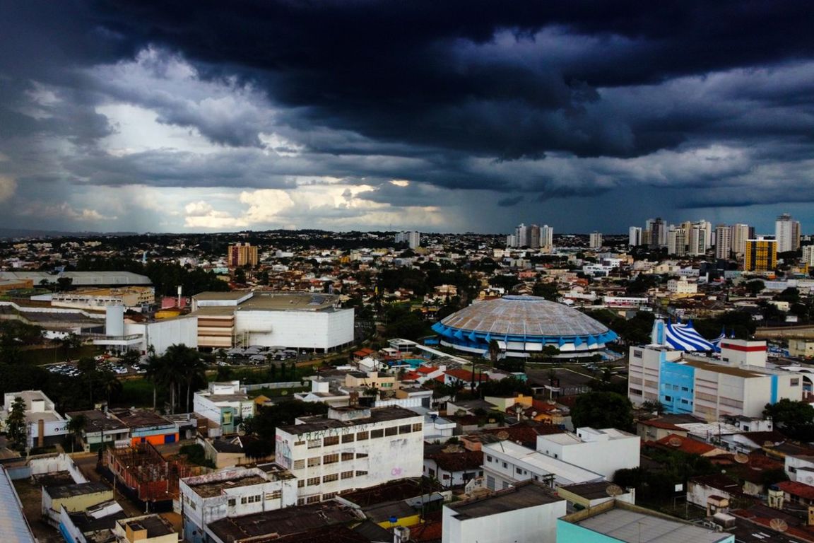 Nuvens escuras cobrem o céu sobre os prédios de uma cidade goiana