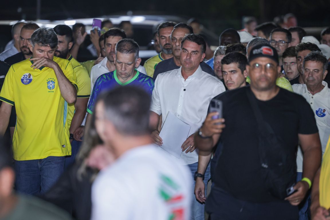 Flávio Bolsonaro cercado de aliados ao falar com jornalistas na noite da derrota, em Brasília