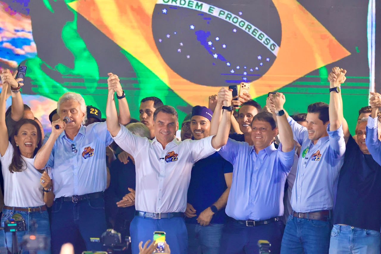 Lideranças políticas de mãos dadas e erguidas no palco do ato em Goiânia