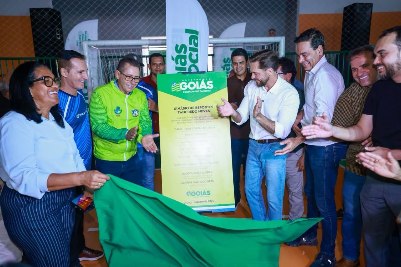 Autoridades aplaudem diante da placa de inauguração do Ginásio de Esportes Tancredo Neves, em Uruaçu