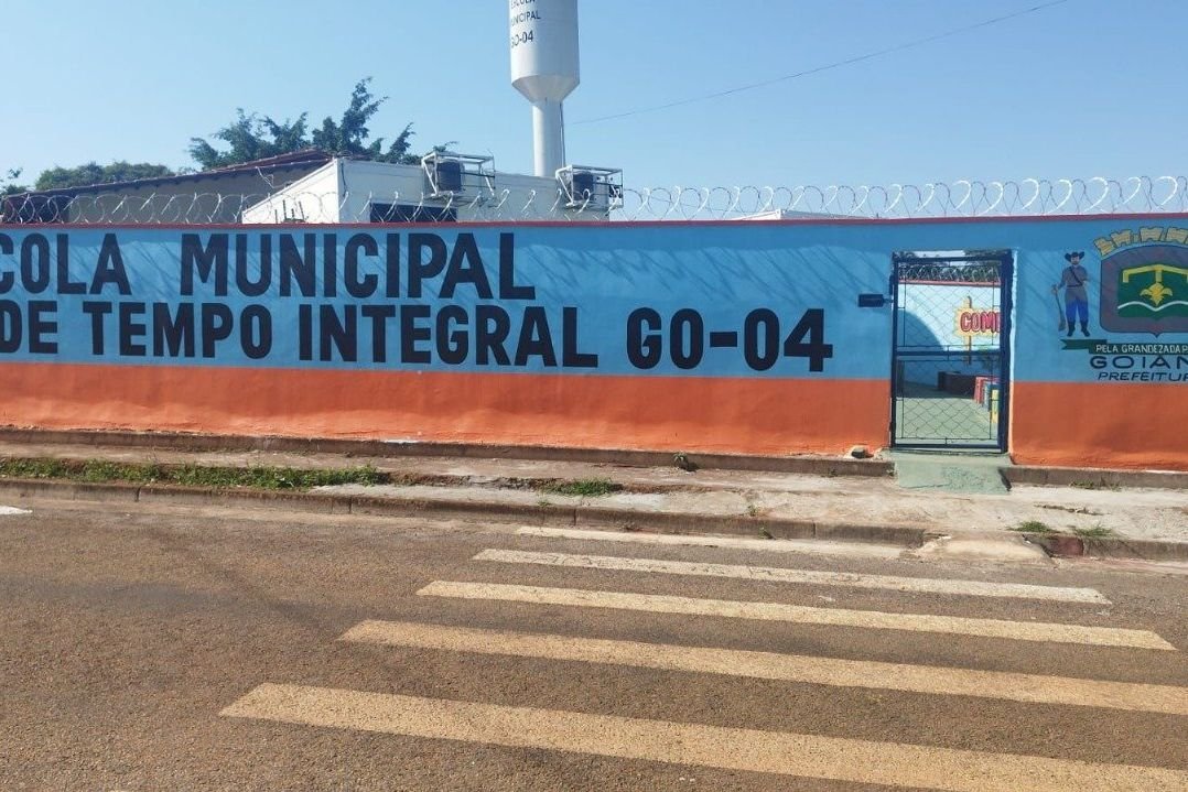 Fachada de escola municipal de tempo integral de Goiânia, com o nome da unidade pintado no muro