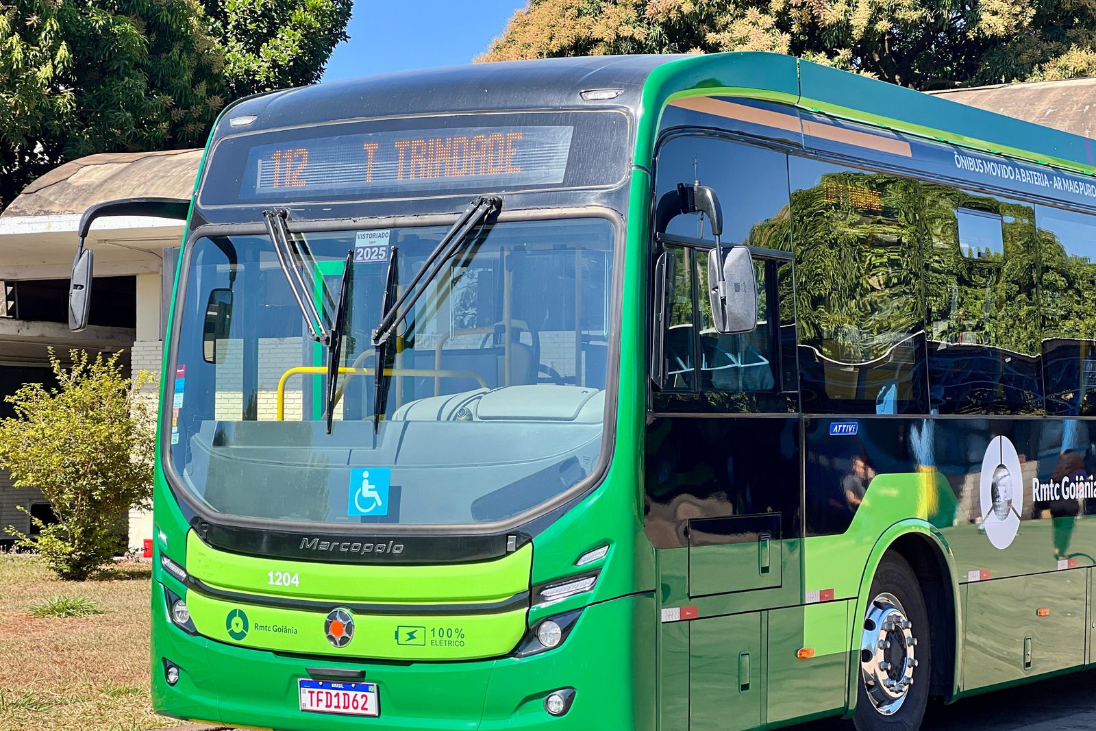 &Ocirc;nibus urbano verde, com destino Terminal Trindade no letreiro, parado em via arborizada
