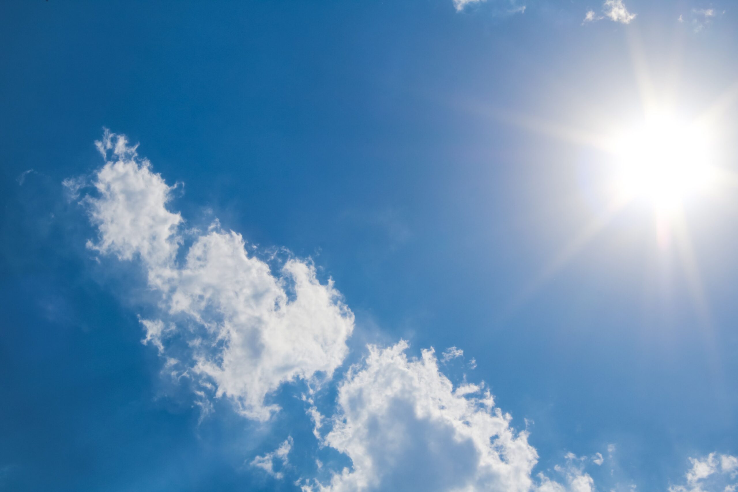 Céu azul com sol forte e poucas nuvens, em dia de calor e baixa umidade do ar