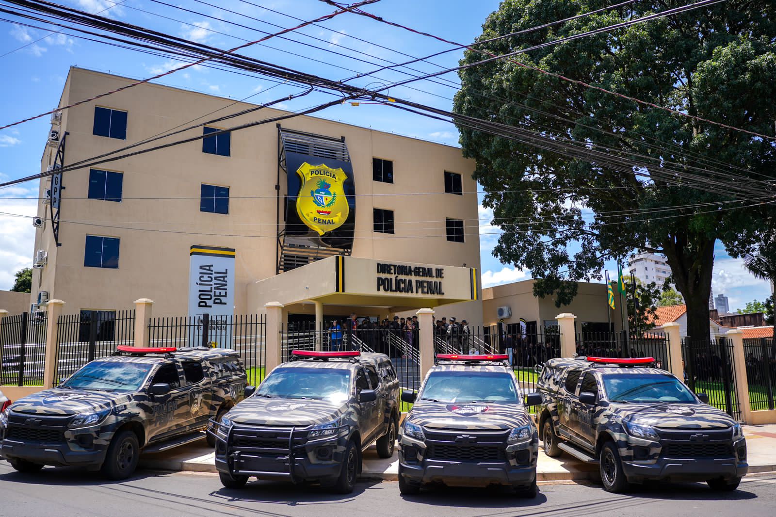 Fachada da Diretoria-Geral de Polícia Penal de Goiás, com viaturas estacionadas em frente