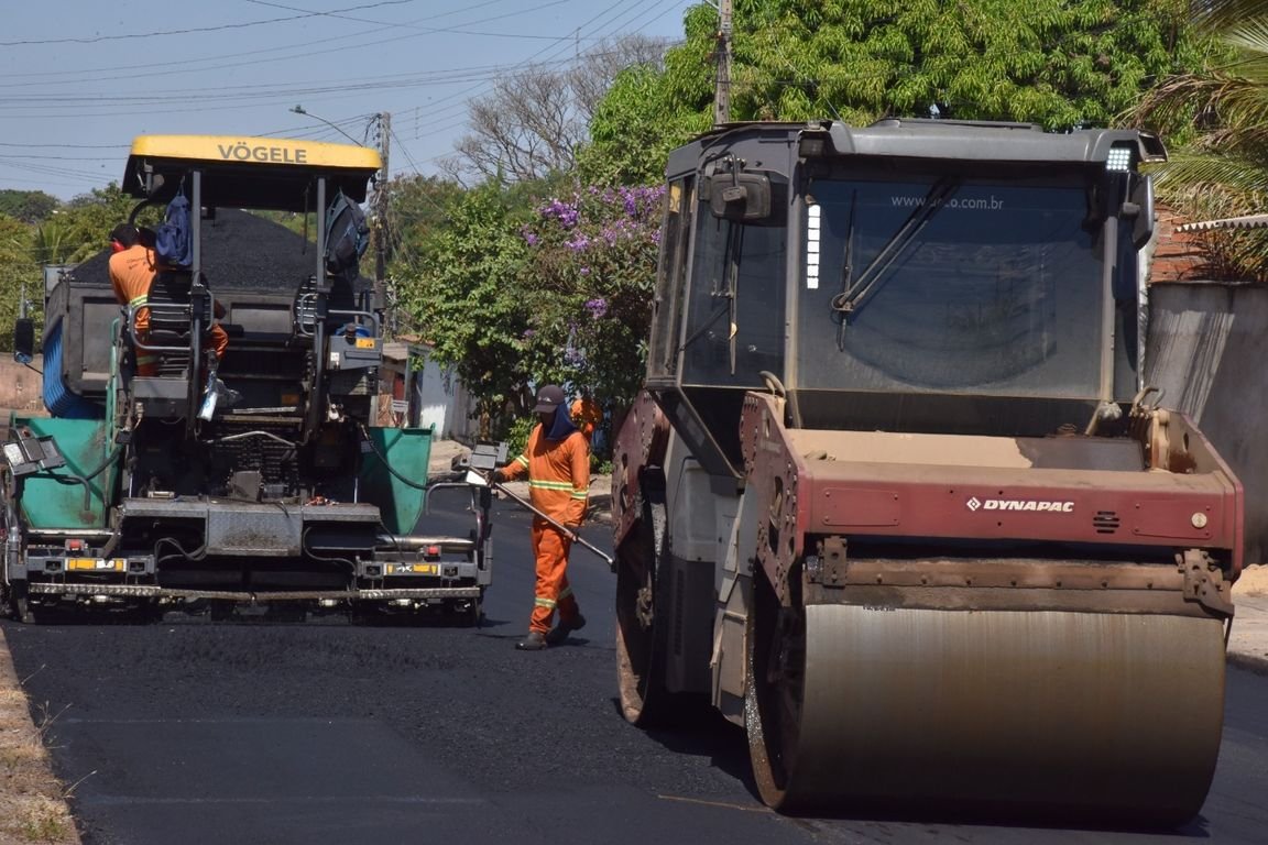 Máquinas de pavimentação e rolo compactador em obra de asfalto em rua de Aparecida de Goiânia
